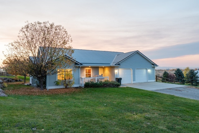 ranch-style home with covered porch, a garage, and a lawn