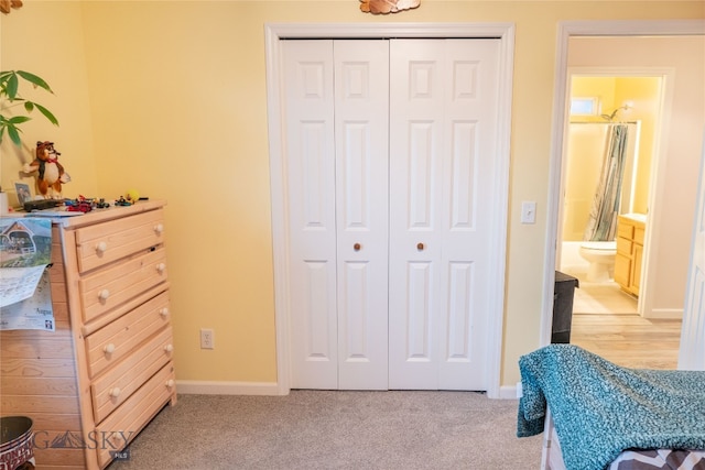 carpeted bedroom featuring connected bathroom and a closet