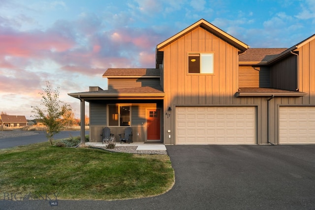 view of front of property with a garage and a lawn