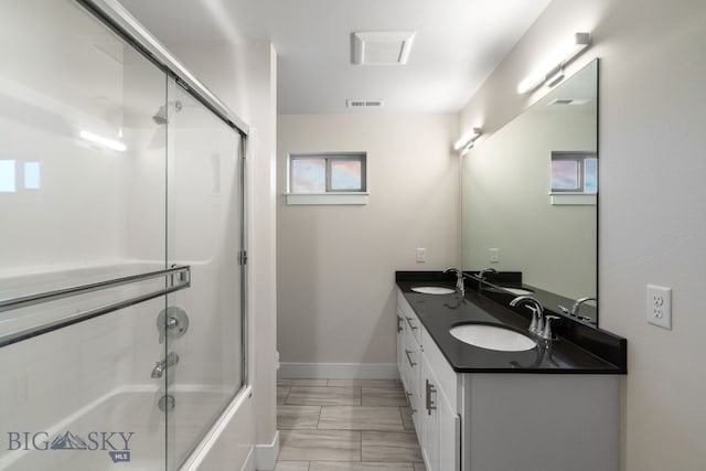 bathroom featuring vanity and shower / bath combination with glass door