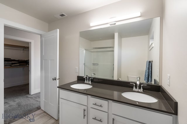 bathroom featuring vanity, toilet, and an enclosed shower