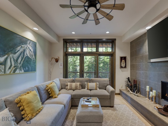 living room featuring a fireplace and ceiling fan