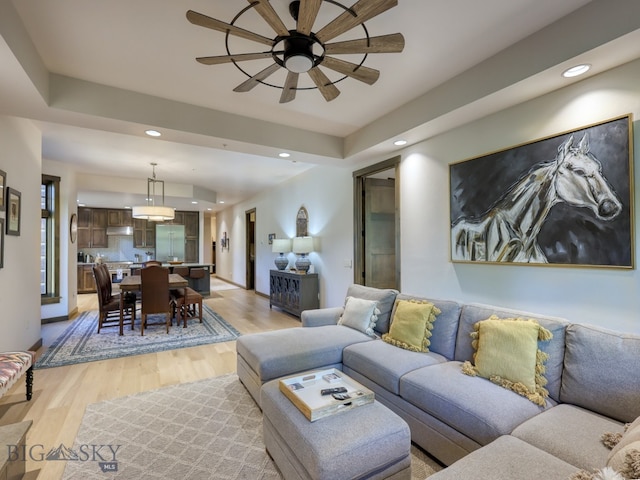 living room featuring light hardwood / wood-style floors and ceiling fan