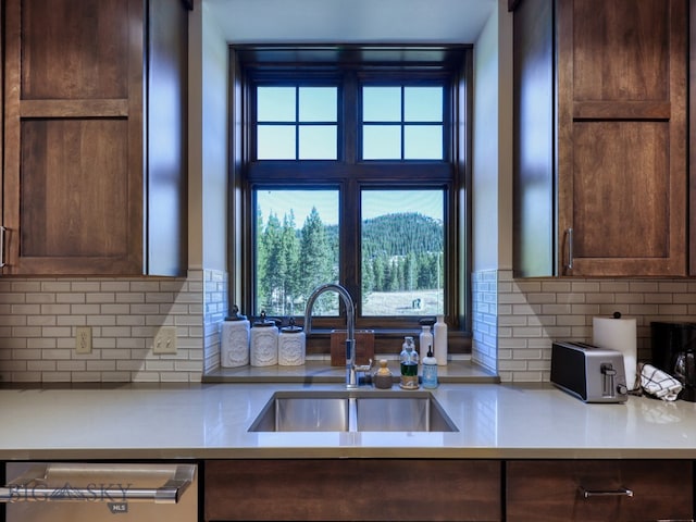 kitchen with sink, dark brown cabinetry, dishwasher, and backsplash