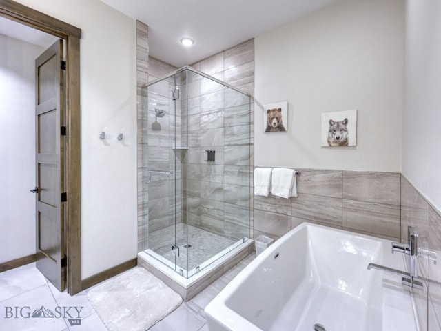 bathroom featuring tile patterned flooring and separate shower and tub