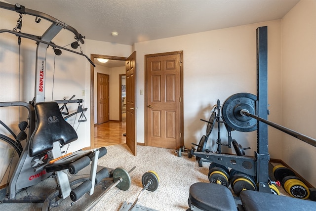 exercise room with carpet and a textured ceiling