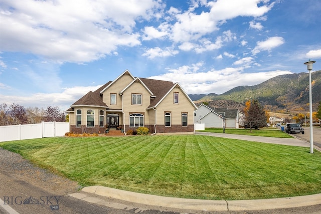 view of front of property featuring a mountain view and a front lawn