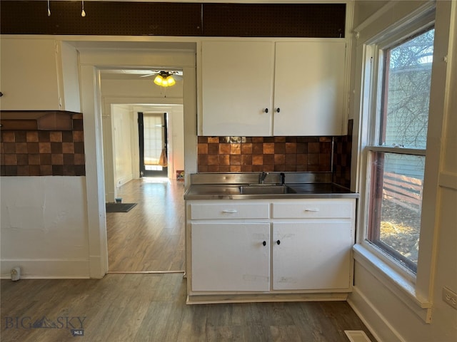 kitchen featuring white cabinetry, ceiling fan, decorative backsplash, and dark hardwood / wood-style floors