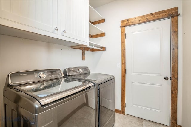 laundry room featuring cabinets, separate washer and dryer, and light tile patterned floors