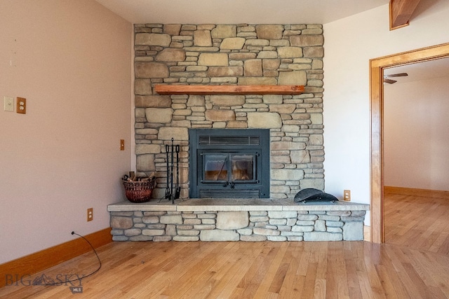 room details with hardwood / wood-style flooring and a stone fireplace