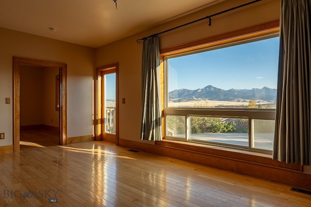 empty room with a mountain view and light wood-type flooring