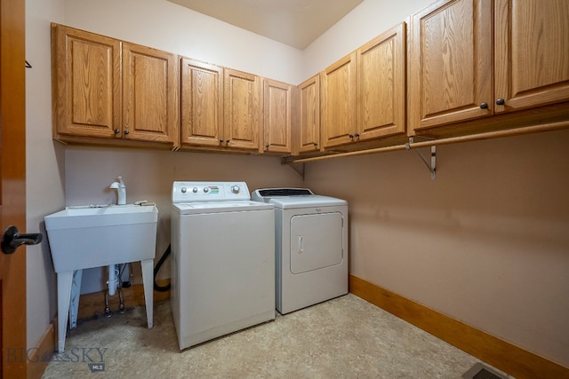 washroom with cabinets, sink, and washing machine and dryer