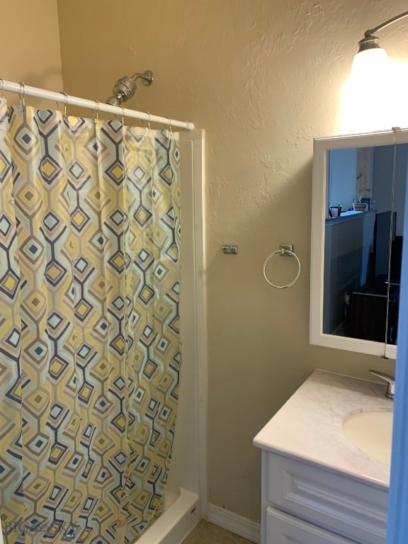 bathroom featuring vanity and curtained shower