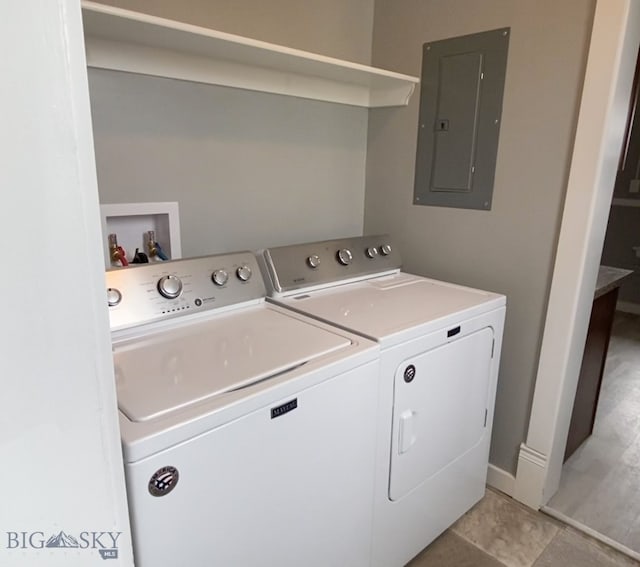 laundry area with electric panel, light tile patterned floors, and washer and dryer