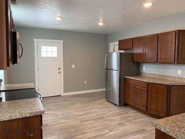 kitchen featuring light hardwood / wood-style floors and appliances with stainless steel finishes