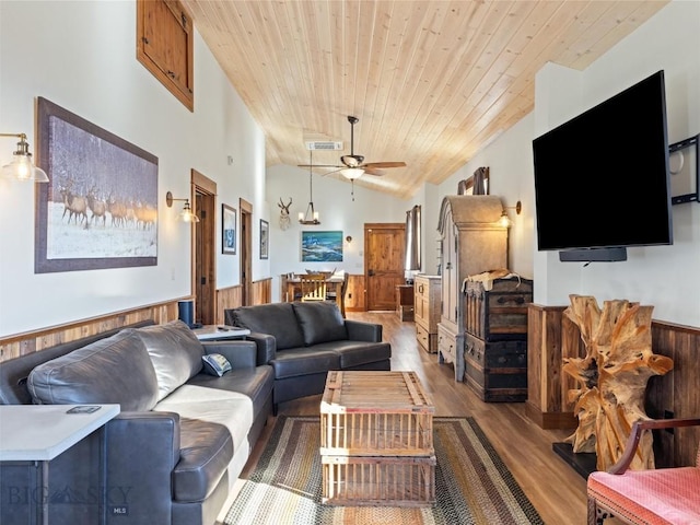 living room featuring a ceiling fan, visible vents, wood ceiling, a wainscoted wall, and wood finished floors