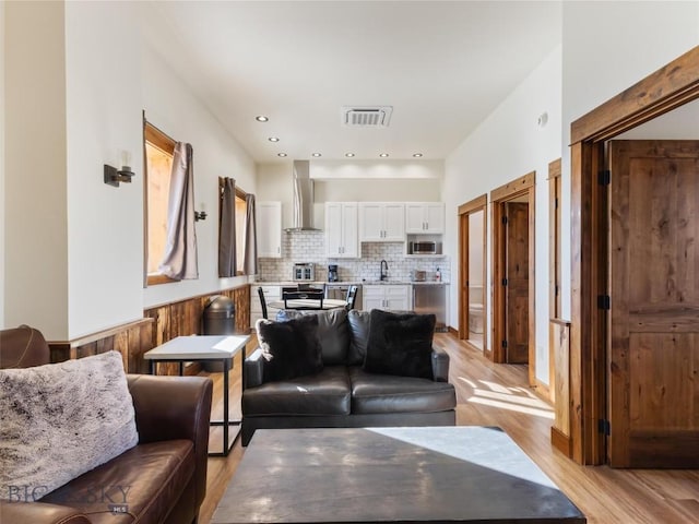 living room with recessed lighting, visible vents, and light wood-type flooring