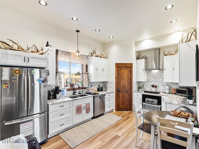 23 Caspari Way E, Emigrant, MT 59027 - kitchen with stainless steel appliances, wall chimney exhaust hood, backsplash, white cabinetry, and recessed lighting