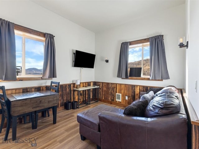 living room featuring wainscoting, visible vents, and wood finished floors
