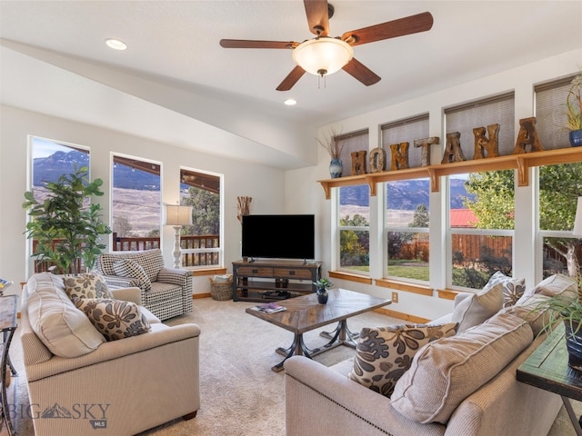 carpeted living room with ceiling fan