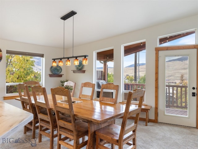 carpeted dining room with vaulted ceiling and a mountain view