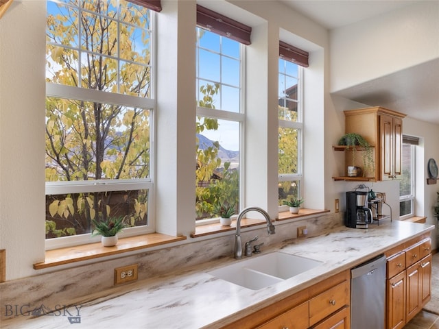 kitchen featuring sink, light stone countertops, dishwasher, and plenty of natural light