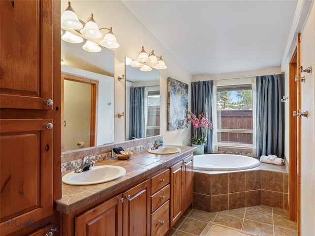 bathroom with vanity, tile patterned floors, lofted ceiling, and tiled tub