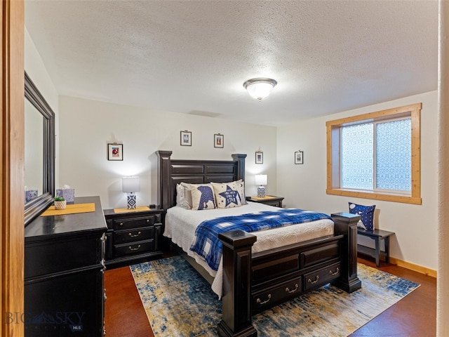 bedroom featuring a textured ceiling and dark hardwood / wood-style flooring