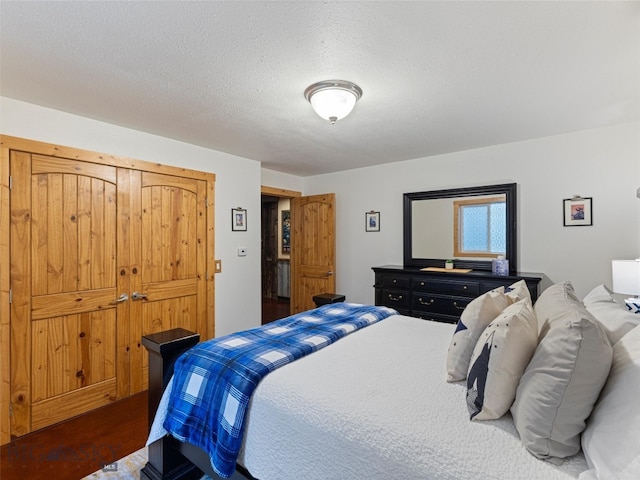 bedroom featuring a closet, a textured ceiling, and hardwood / wood-style floors