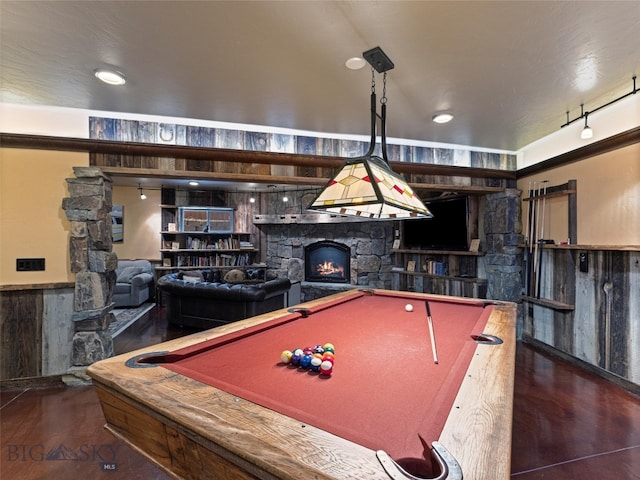 rec room with dark wood-type flooring, wooden walls, pool table, and a fireplace