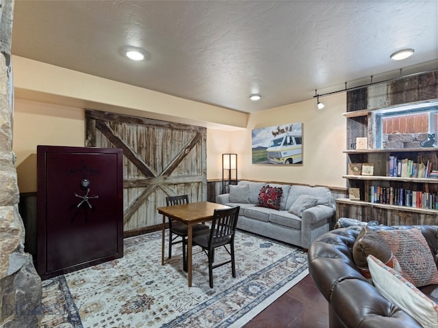 living room featuring a barn door and a textured ceiling