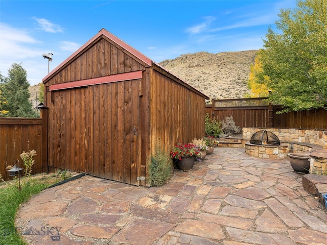 view of outbuilding with a mountain view and a fire pit