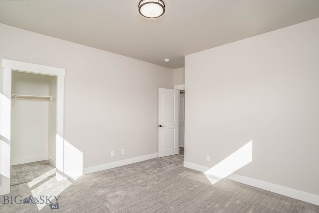 unfurnished bedroom featuring light colored carpet and a closet