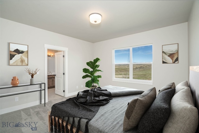 bedroom with connected bathroom and light colored carpet