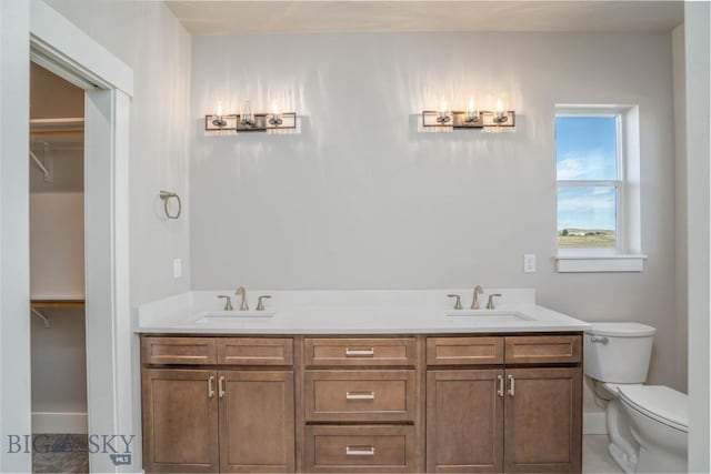 2 Smooth Brome Ct, Three Forks, MT 59752 - full bathroom with a sink, toilet, baseboards, and a walk in closet