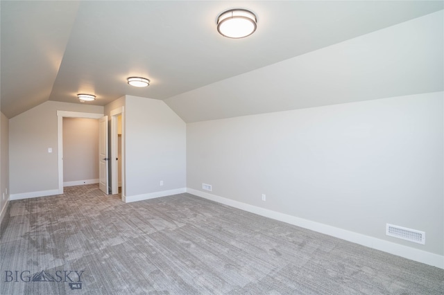 additional living space with lofted ceiling and light carpet