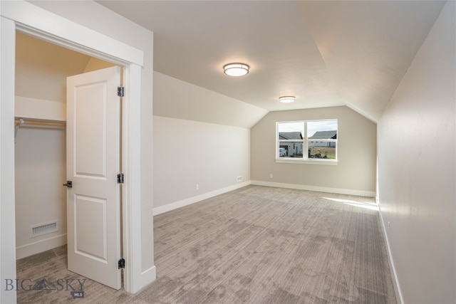 bonus room with light colored carpet and lofted ceiling