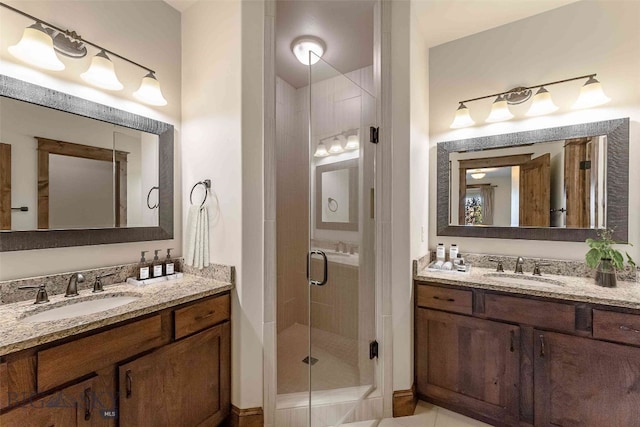 bathroom with vanity, a shower with shower door, and tile patterned floors