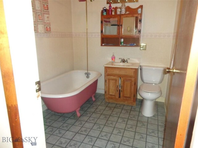 112 Washington St, Anaconda, MT 59711 - bathroom featuring a soaking tub, toilet, vanity, and tile patterned flooring