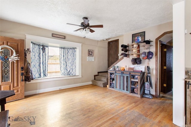 interior space with ceiling fan, wood-type flooring, and a textured ceiling