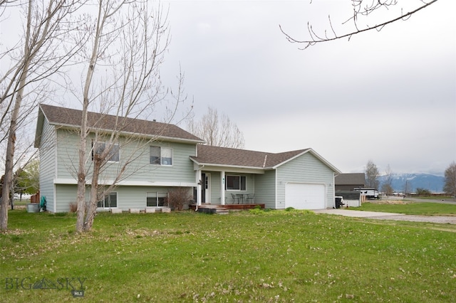 tri-level home featuring a front lawn and a garage