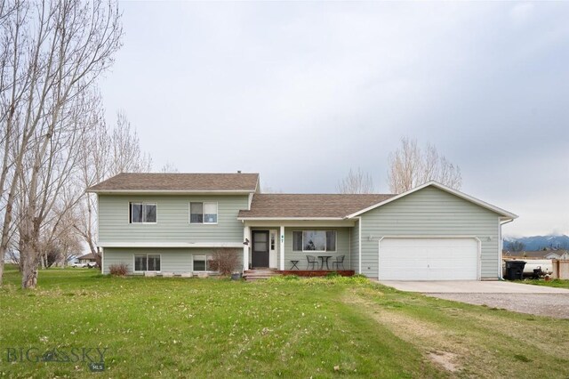 97 Ghost Canyon Ct, Belgrade, MT 59714 - tri-level home with driveway, a shingled roof, an attached garage, a porch, and a front lawn