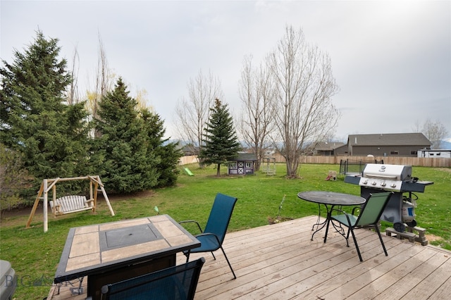 deck with a yard, area for grilling, and a shed