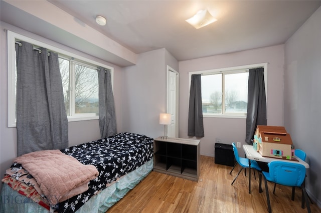 bedroom featuring wood-type flooring and multiple windows