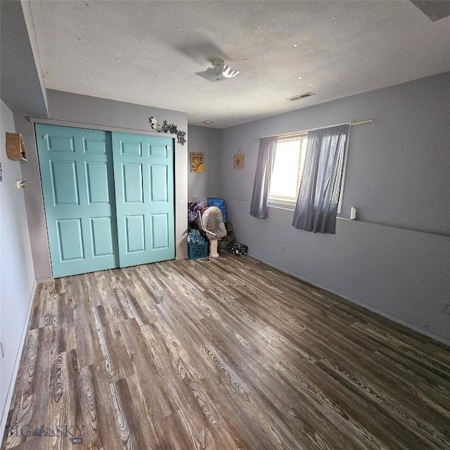 97 Ghost Canyon Ct, Belgrade, MT 59714 - unfurnished bedroom featuring visible vents, wood finished floors, and a closet