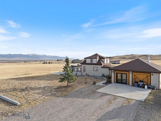 193 Tobe Rd, Ennis, MT 59729 - view of front facade featuring a mountain view, french doors, and driveway