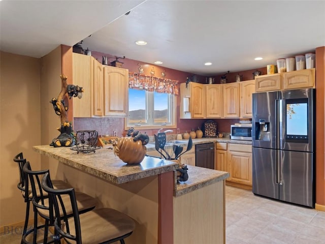 193 Tobe Rd, Ennis, MT 59729 - kitchen with appliances with stainless steel finishes, light brown cabinetry, a peninsula, a kitchen bar, and recessed lighting