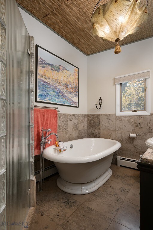 bathroom with vanity, a bathing tub, and baseboard heating