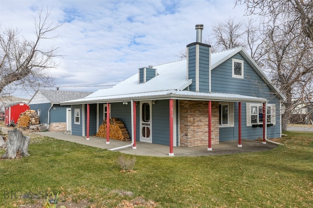 back of property featuring covered porch and a lawn