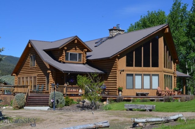 155 Moose Run, Polaris, MT 59746 - back of property with log siding, a chimney, and covered porch